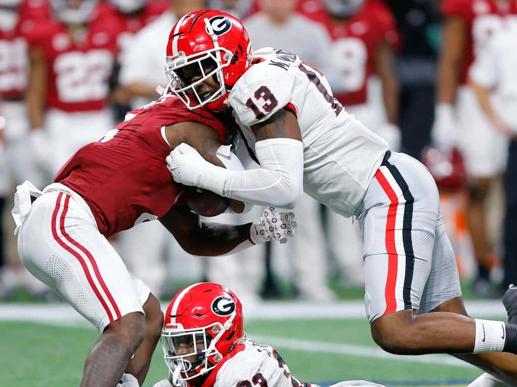 ATLANTA, GEORGIA - DECEMBER 02: Mykel Williams #13 and Tykee Smith #23 of the Georgia Bulldogs tackle Roydell Williams #5 of the Alabama Crimson Tide during the third quarter in the SEC Championship at Mercedes-Benz Stadium on December 02, 2023 in Atlanta, Georgia. (Photo by Todd Kirkland/Getty Images)